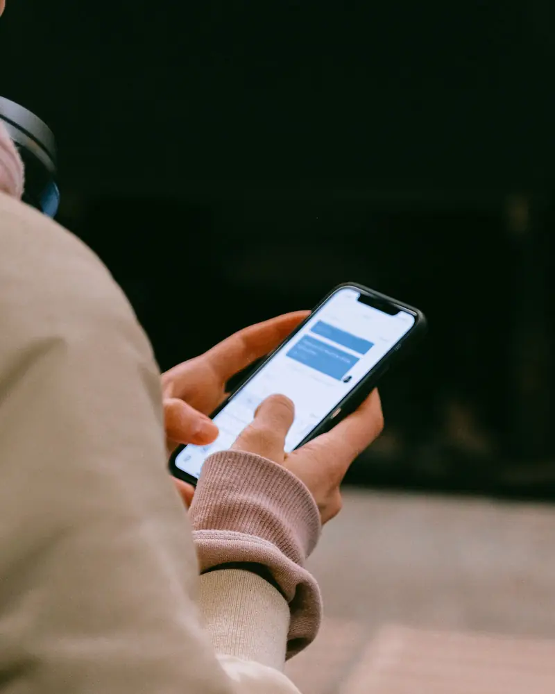 Hands holding a phone with a text message conversation